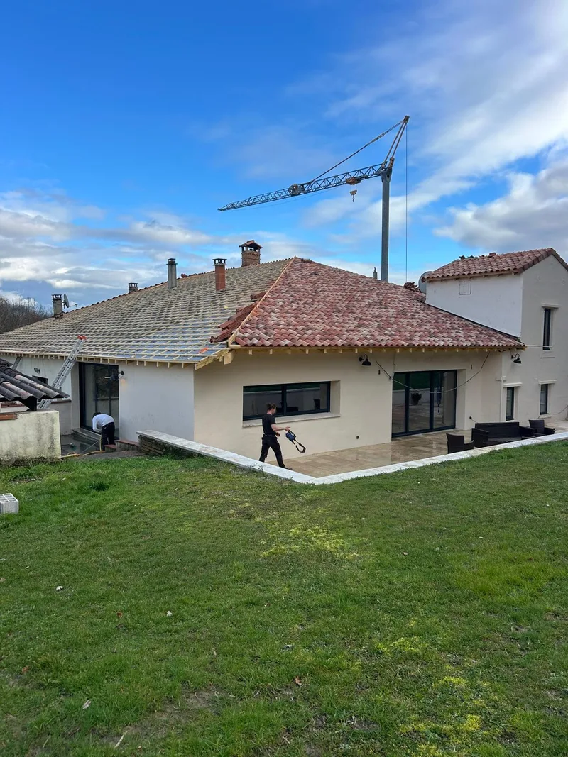 Chantier de toiture avec grue sur une grande maison
